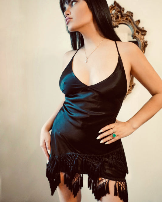 Beautiful girl in a black short viscose dress with fringes